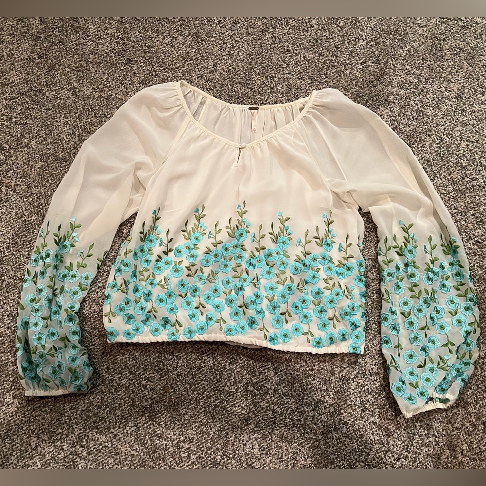 Small Free People cream blouse with embroidered flowers.